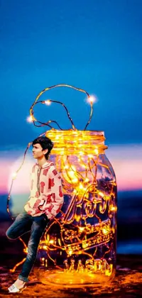 The phone live wallpaper showcases an enchanting depiction of a woman sitting inside a jar surrounded by twinkling fairy lights against a stunning sunset backdrop