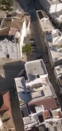 This phone live wallpaper showcases a beautiful bird's eye view of a bustling city in Happening, Nazare (Portugal) with an ancient cathedral in the background, creating a historical vibe