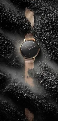 This phone live wallpaper depicts a minimalist design showing a watch in rose gold against a black surface