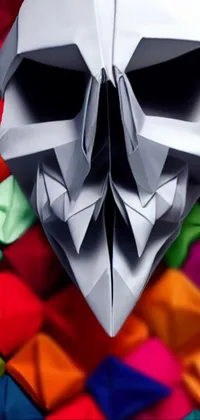 This live wallpaper showcases a stunningly detailed skull crafted out of folded origami paper, featuring an occult silver mask
