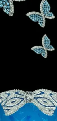 This phone live wallpaper showcases a pair of stunning butterfly brooches in blue and white colors, complemented by an album cover and DeviantArt inspired graphics