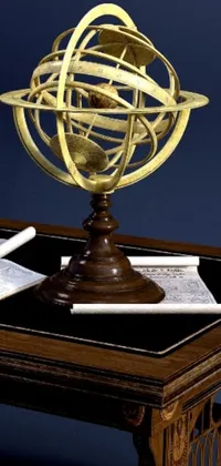 This stunning phone live wallpaper features an exquisite desk with a world globe on top, adorned with intricate armillary rings jewelry