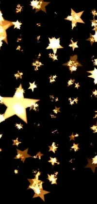 Looking for a stunning live wallpaper for your phone? Look no further than this breathtaking design, featuring a collection of gold stars set against a deep black background