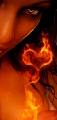 This live phone wallpaper showcases a close-up of a woman's hand holding a cell phone against a backdrop of fire and smoke