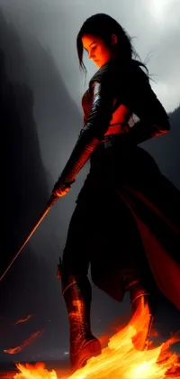 This phone live wallpaper showcases a stunning image of a female rogue assassin standing bravely in front of a blazing fire, brandishing a sword with determination