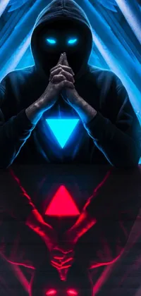 This live wallpaper showcases a digital design with a man in a dark hoodie sitting at a table, featuring intricate triangular shapes in shades of red and cyan