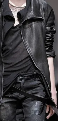 This phone live wallpaper is inspired by black design and Tumblr fashion, featuring a woman wearing a sleek leather jacket and skinny belt walking down a runway