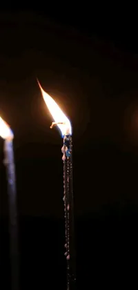 This phone live wallpaper showcases a beautiful group of lit candles resting on a wooden table