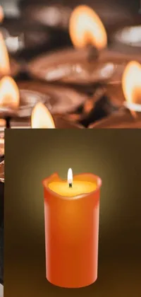 This live wallpaper features a group of candles on a table, emitting a pleasant light orange mist