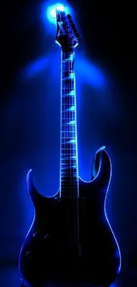 Get ready to rock with this dynamic phone live wallpaper! Featuring a stunning black electric guitar sitting on a table, this design is set against a beautiful pixabay background