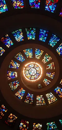 This live wallpaper depicts a circular stained glass window with intricate designs in a church