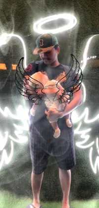 This live wallpaper displays a powerful image of a man holding a baby in front of a grand neon angel
