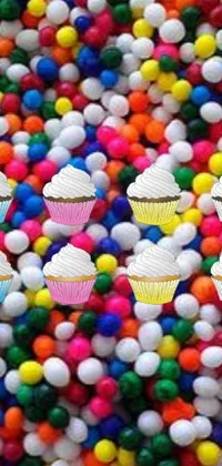 This phone live wallpaper features a group of cupcakes on a colorful ball pit