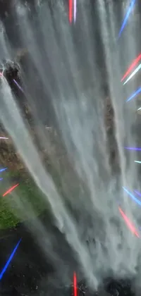 Experience the world of pure imagination with this mesmerizing live phone wallpaper! A group of people stands in front of a cascading waterfall, captured from a close-up aerial view in a video art style perfect for fanatics of futuristic beings and laser lights