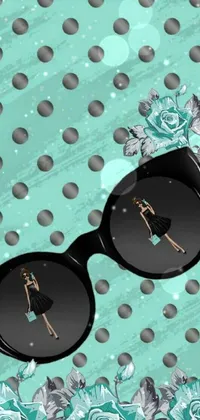 This eye-catching phone live wallpaper features a trendy pair of sunglasses set on a table against a black and teal paper pattern