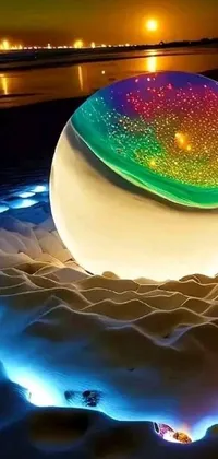 This live phone wallpaper features a stunning glowing orb set atop a sandy beach, providing an interactive and artful experience for your mobile device