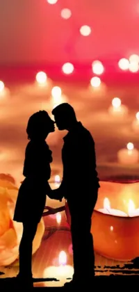 This romantic phone live wallpaper depicts a couple in front of flickering candles within an intimate ambiance
