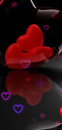 Looking for a stunning live wallpaper that will add beauty and romance to your phone? Look no further than this popular design featuring two vibrant red hearts sitting atop a sleek black surface