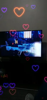 This phone live wallpaper features a flat screen TV resting on a wooden table, with a hologram display and pink hearts embellishing the backdrop