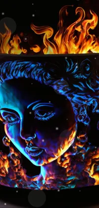 This live wallpaper for your phone features an intricately painted fire pit with a woman's face design, inspired by ultrafine art techniques