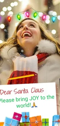 This live phone wallpaper features a cheerful woman holding a sign that reads "Dear Santa Claus, Please Bring Joy to the World"