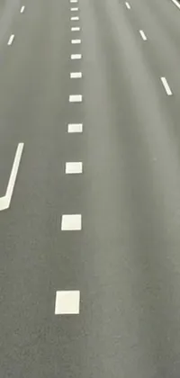 This live phone wallpaper features a highway with a painted arrow on the side, inspired by a contemporary video still