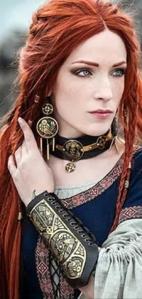 This live phone wallpaper features a fierce woman with red hair wearing metal shoulder pauldrons and a Celtic hair braid