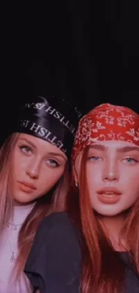 This live phone wallpaper features two women standing together wearing bandanas