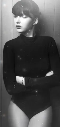 This phone live wallpaper captures a black and white photograph of a woman in a bodysuit and draped in a black sweater