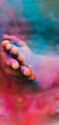 This stunning live wallpaper features a colorized photo of a woman holding a cell phone covered in colored powder, capturing the spirit of the Holi festival of rich color