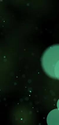 This digital art phone live wallpaper features blurry lights on a black background, with green sparkles, bubbles VFX, and multiple moons glowing in the distance
