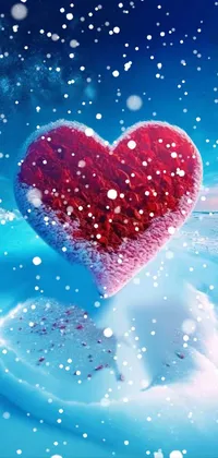 This live wallpaper features a heart shape floating atop a peaceful blue body of water with gentle snowflakes falling