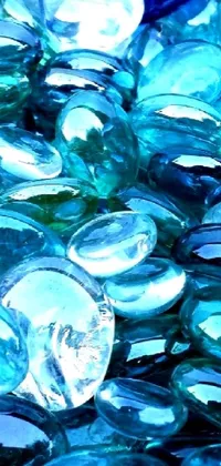This live phone wallpaper features an eye-catching design of blue glass pebbles resting on a table