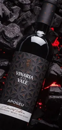This stunning live wallpaper depicts a wine bottle resting on a coal pile, with a background of a Voronoi pattern
