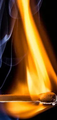 This phone live wallpaper showcases a close-up of a burning match on a black backdrop