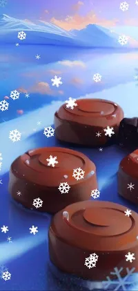 This phone live wallpaper showcases a group of chocolates resting on a snow-covered ground with smooth round shapes