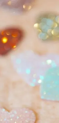 This phone live wallpaper from Tumblr displays glitter hearts up close on a table, shining in amethyst, citrine and opal colors
