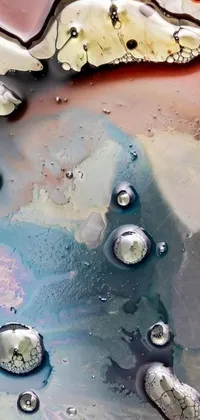 Looking for a unique and mesmerizing live wallpaper for your phone? Check out this close-up image of oil and water mixed together