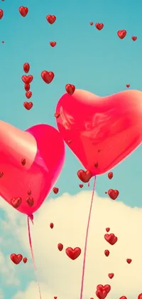 This phone live wallpaper showcases two vibrant red heart-shaped balloons drifting across a flawless clear blue vintage-inspired sky