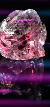 This phone live wallpaper features a stunning pink diamond sitting atop a sleek black surface, reflecting light brilliantly