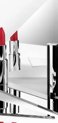 This live wallpaper showcases two striking red lipsticks sitting on top of a sleek mirror