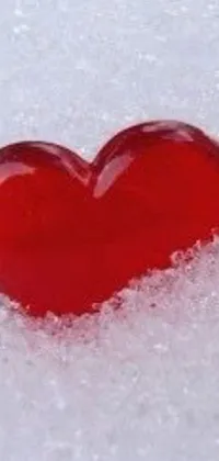 This red heart live wallpaper features a charming snowy backdrop that creates a perfect contrast for the vivid red of the heart