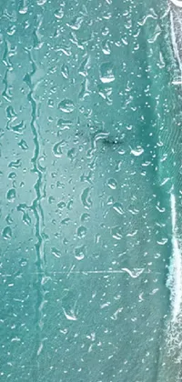 This stunning phone wallpaper showcases a close-up view of water droplets on a window
