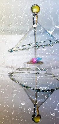 This live phone wallpaper features an exquisite drop of water resting atop water's surface