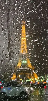 Transform your phone's look with this stunning live wallpaper featuring the Eiffel Tower viewed through a rain-spattered window