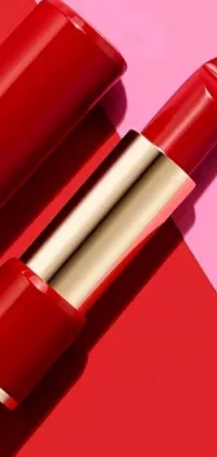 This stylish live wallpaper features a close-up of a red lipstick on a pink and red background, with accents in gold and red