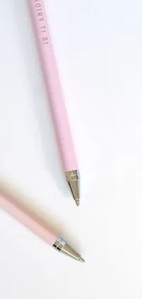 This phone live wallpaper features an exquisitely detailed image of two pink pens side by side