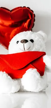 Adorn your phone screen with a delightful live wallpaper - a charming white teddy bear seated beside a red heart-shaped balloon