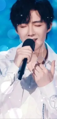Enhance your phone screen with this aesthetic live wallpaper! Featuring a man in a white shirt holding a microphone, this image captures the essence of a talented performer