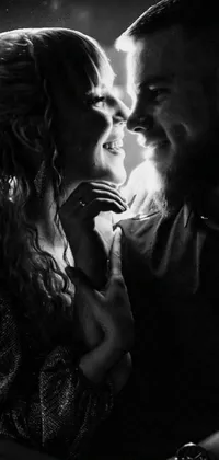Elevate the aesthetic appeal of your phone with this black and white live wallpaper featuring a glowing backlit portrait of a couple